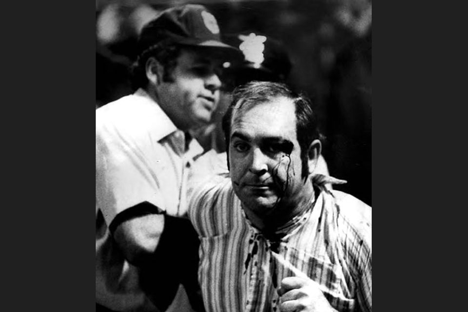 Umpire Joe Brinkman leads a bleeding fan off the field during the riot. (photo courtesy of the Cleveland Press Collection, Michael Schwartz Library, Cleveland State University)