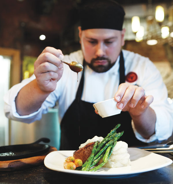 A chef at The Bistro plates the filet mignon