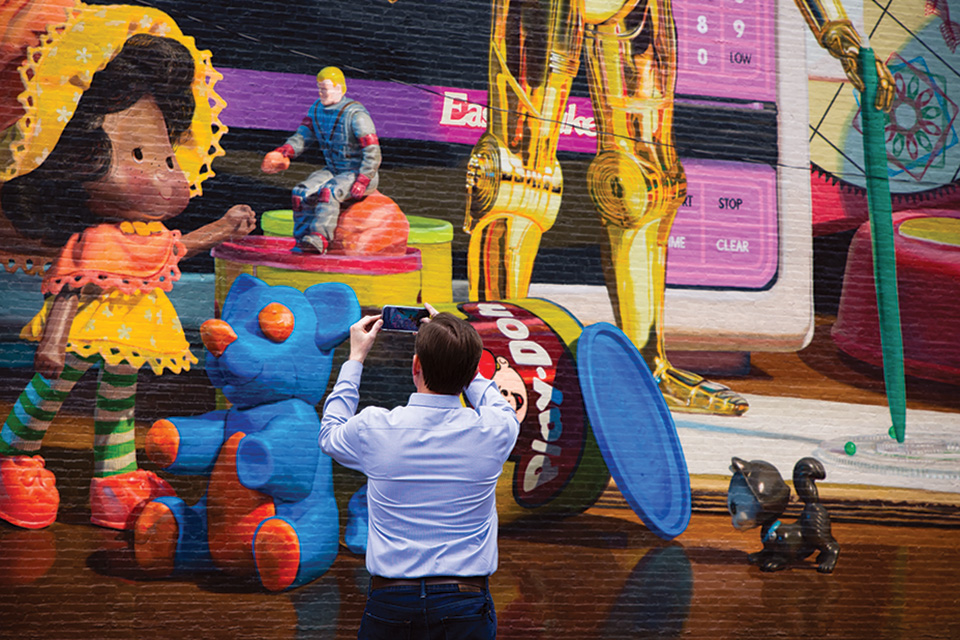 Editor Jim Vickers in front of Cincinnati's toy heritage mural (photo by Stephanie Park)