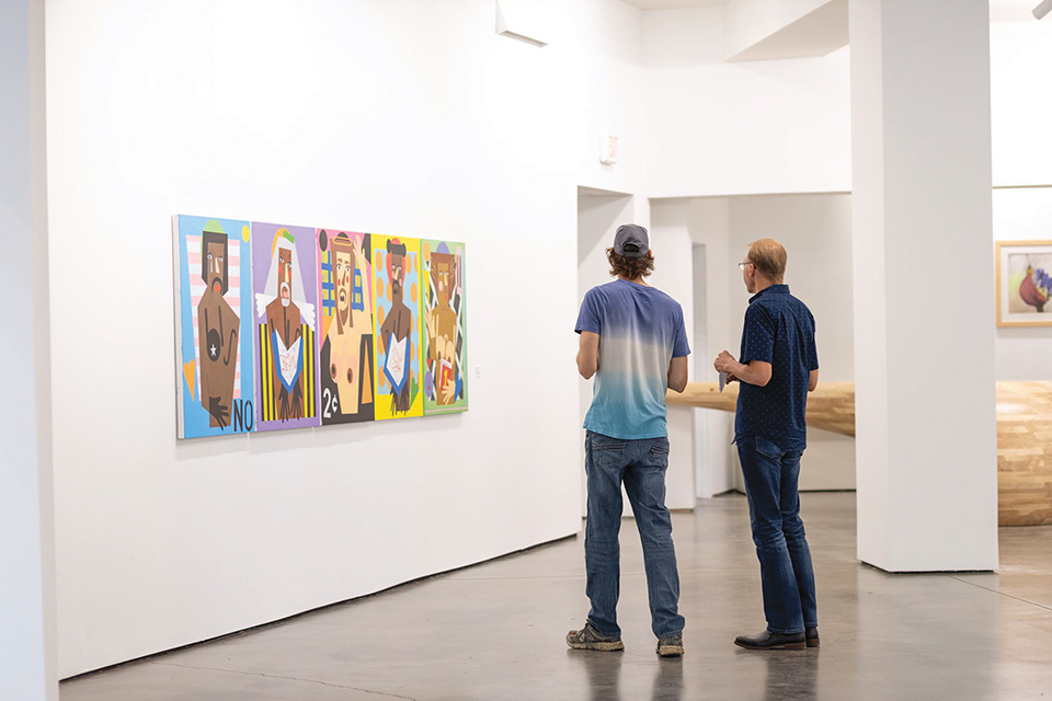 Men looking at artwork at the Dayton Arcade (photo courtesy of Cross Street Partners)