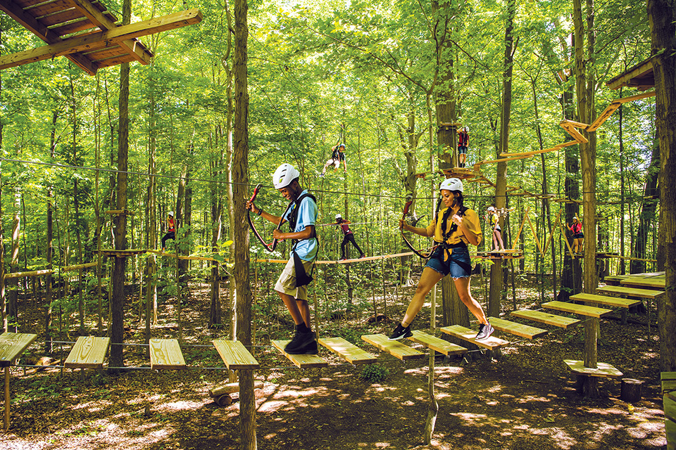 People walking across bridge at Lake Erie Canopy Tours (photo courtesy of Ashtabula County Convention & Visitors Bureau)