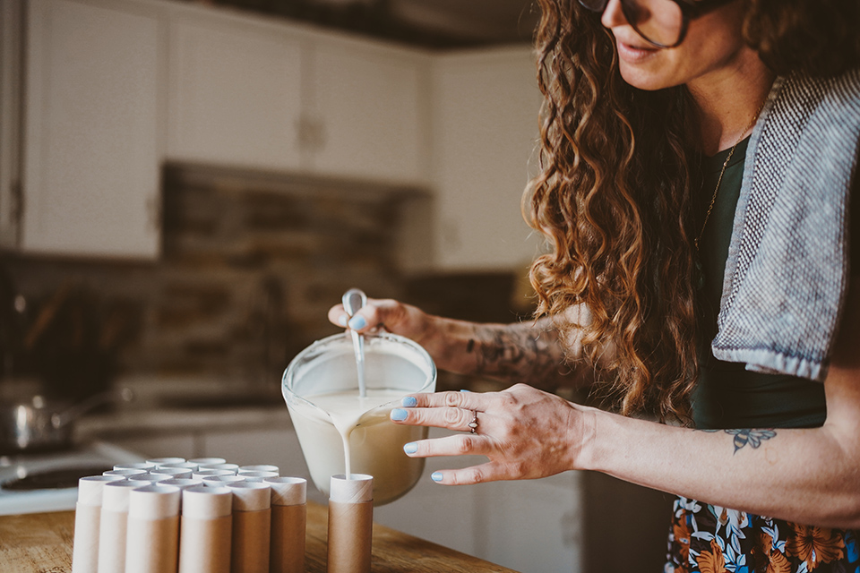 Woman pouring mixture into tubes for a Dayton’s Humble Hive Homemade product (photo by BD Photography)