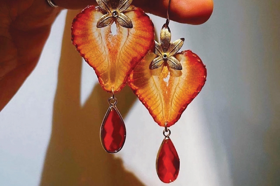 Hand holding strawberry drop earrings from Jupiter Oak (photo courtesy of Jupiter Oak)