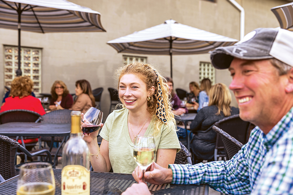 People sitting on the patio and enjoying wine at Olde Schoolhouse Vineyard & Winery in Eaton (photo courtesy of Olde Schoolhouse Winery)