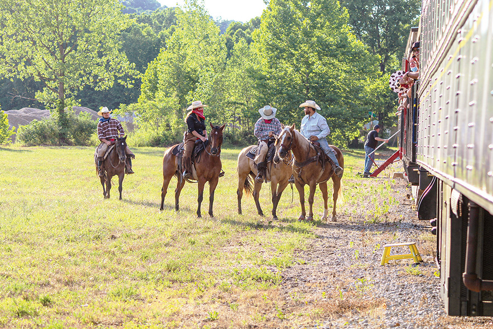 Men on horses next to train at the Hocking Valley Scenic Railway’s Ohio’s Friendliest Train Robbery (photo courtesy of Hocking Valley Scenic Railway)