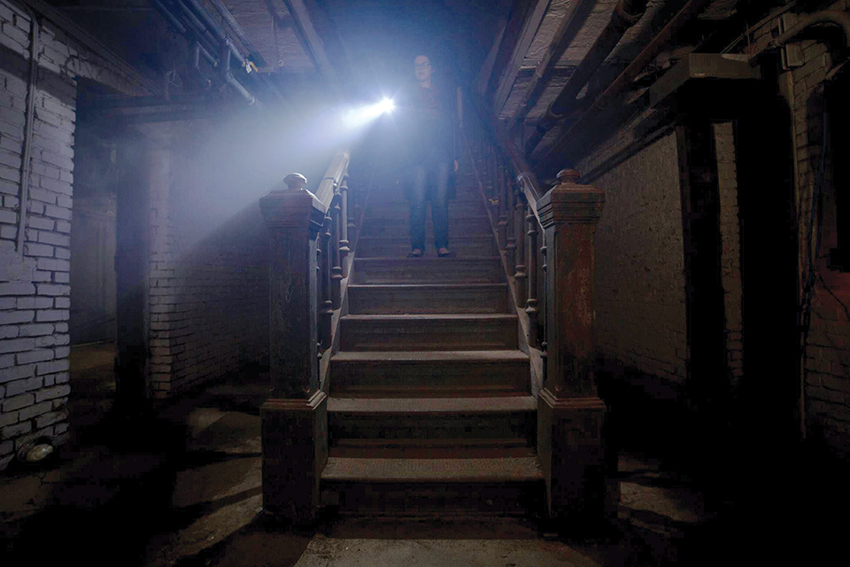 Person touring Mansfield’s Ohio State Reformatory with a flashlight (photo courtesy of Ohio State Reformatory)