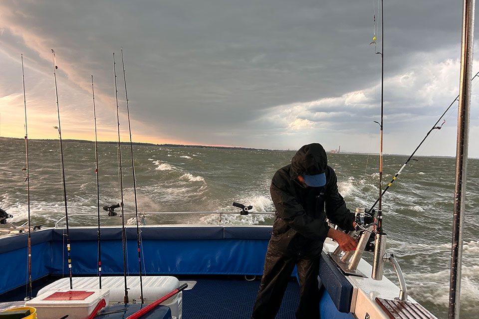 A man holds on to a fishing pole in choppy waters during the Governor’s Lake Erie Fish Ohio Day (photo by Erin Finan)