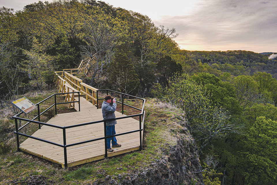 Man at Buzzardroost Rock at the Edge of Appalachia overlook in West Union (photo by David Ike)