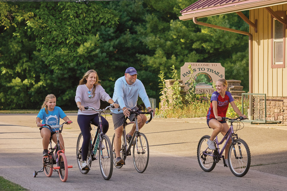 Family riding bikes outside Millersburg Rails to Trails’ Hipp Station (photo by Brian Kaiser)