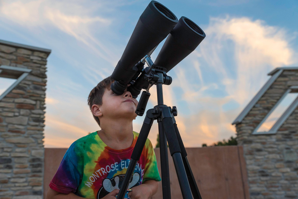 Boy looking into telescope at John Glenn Astronomy Park in Logan (photo by Brad Hoehne)