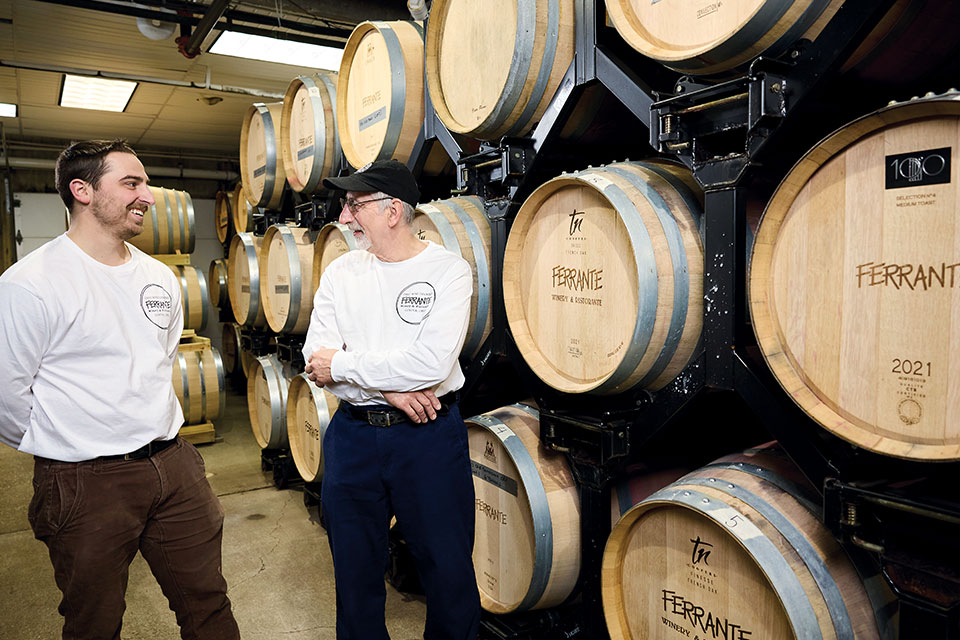 Multiple generations of the Ferrante family pose in front of their wine barrels. 