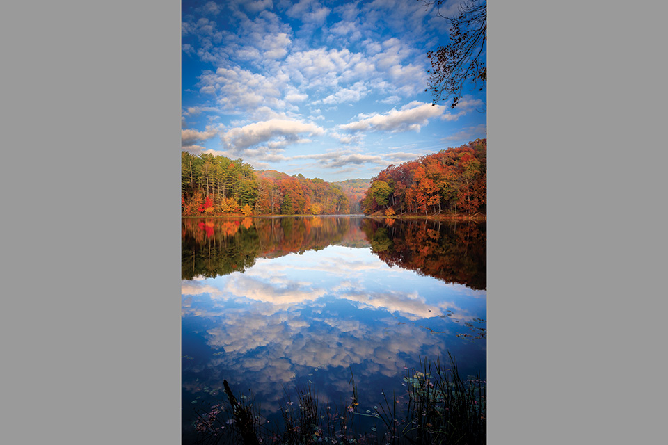 Clouds reflecting on water at Lake Hope State Park in McArthur (photo by Gabe Leidy)