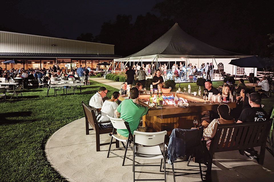 People drinking outdoors at Paper Moon Vineyards in Vermilion (photo courtesy of Paper Moon Vineyards)