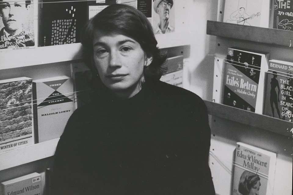 Poet Mary Oliver next to a bookshelf (photo courtesy of Kino Lorber)