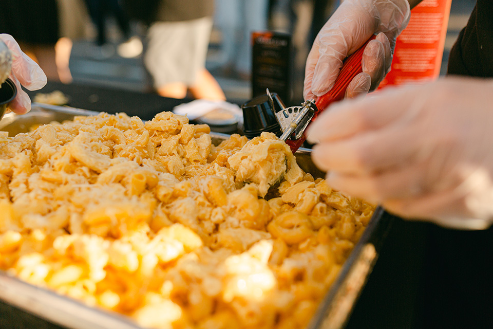 Volunteer scoops mac 'n cheese at Columbus Mac and Cheese Festival (photo by Liz Porter Photography)