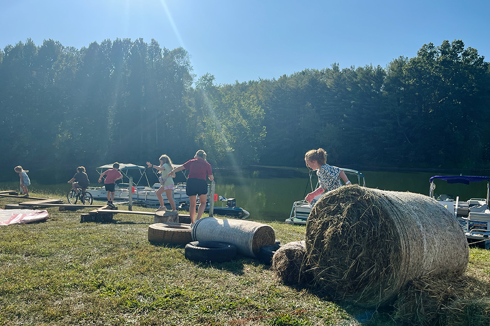 Kids racing on hay bail obstacle course at Paw-Paw Festival in Nelsonville (photo by Rising Appalachia)