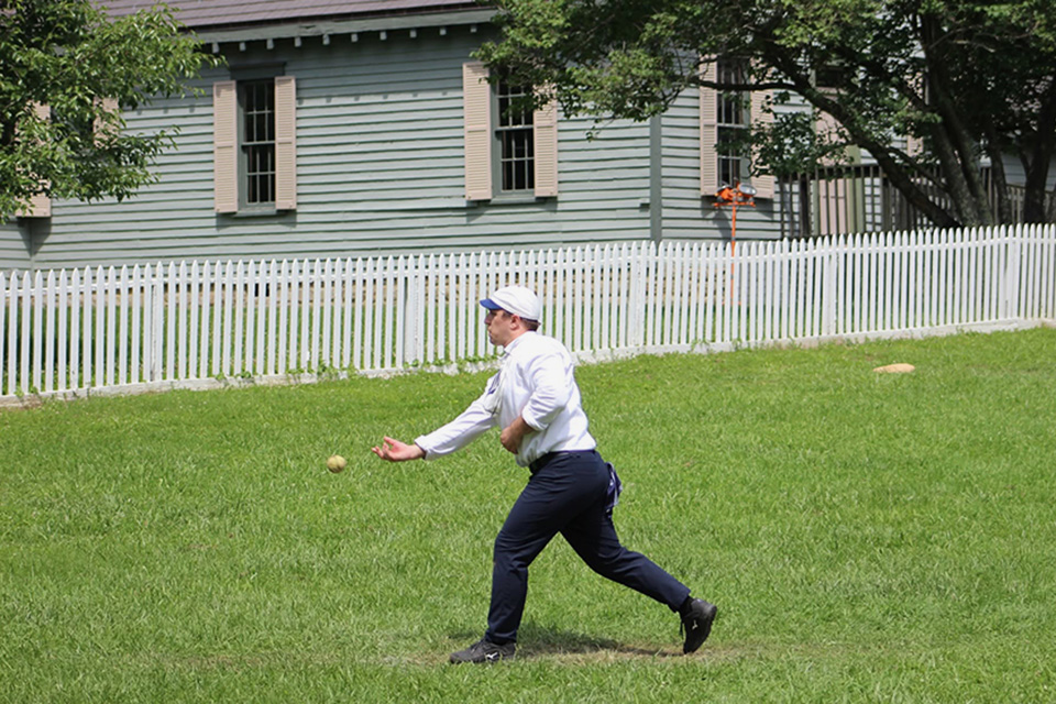 A man pitching a baseball during an old-fashioned game at Sharonville’s Heritage Village Museum (photo courtesy of Heritage Village Museum)