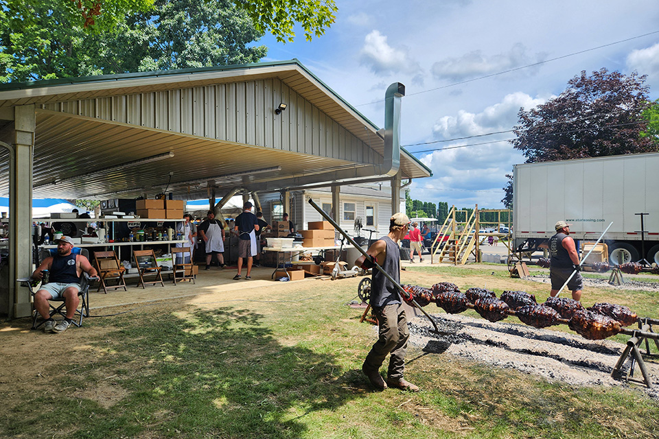 People roasting ox on a spit at Mesopotamia Ox Roast in Mesopotamia Center (photo courtesy of Trumbull County Visitors Bureau)