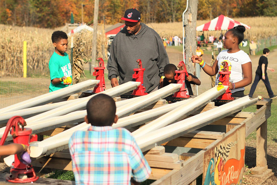 Kids and dad doing duck races at Mapleside Farms’ Pumpkin Village in Brunswick (photo courtesy of Mapleside Farms)