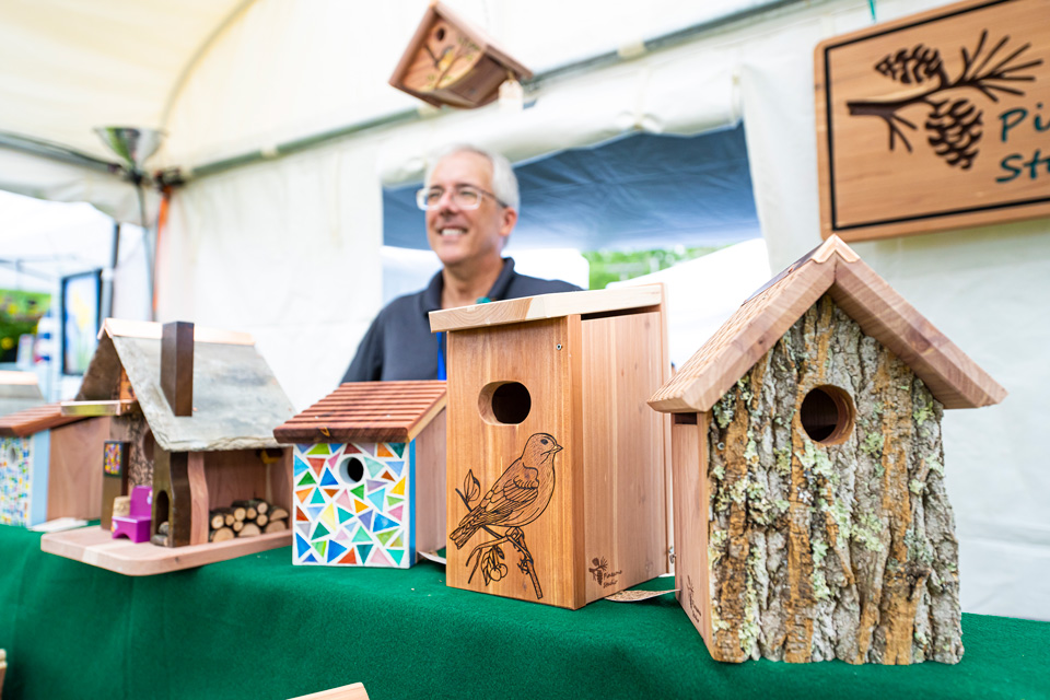 Man with wooden birdhouses (photo courtesy of Jack Pine Studio)