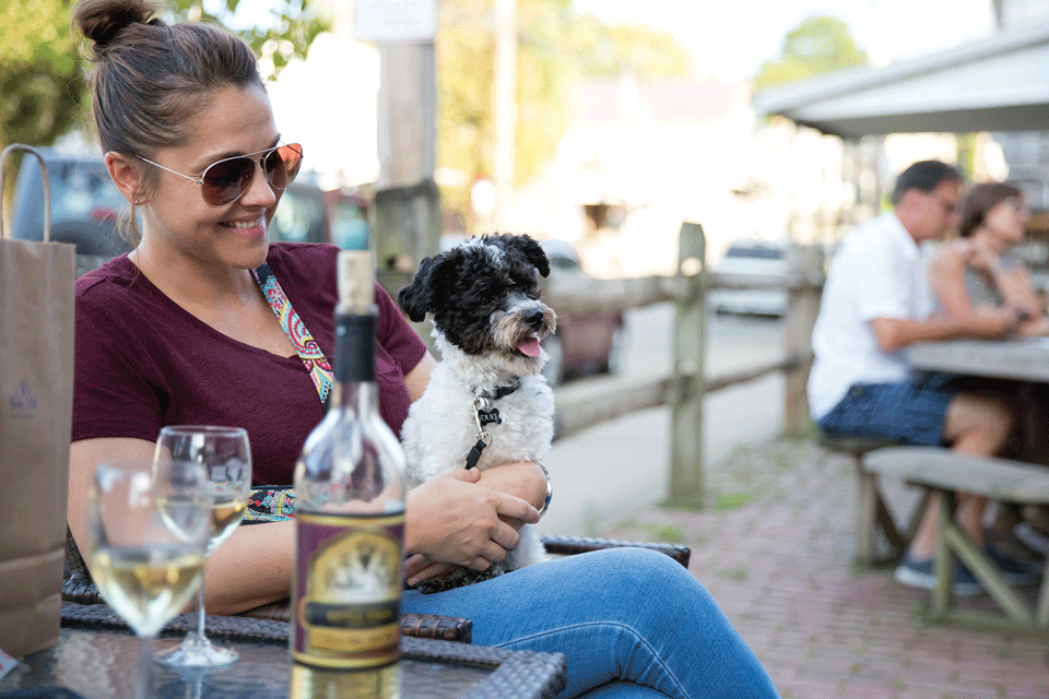 Woman holding dog at Baltic Mill Winery in Baltic (photo by Will Schertz)